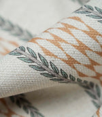 Close-up detail of Varese Rust upholstery fabric showing the woven texture and stylised foliage border.