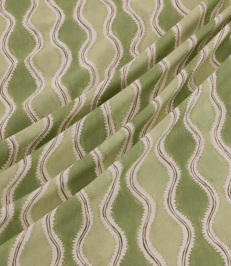 Wading Kelp fabric arranged in soft diagonal folds, showcasing its contemporary wave-inspired stripe design in sage and olive green, with cream scalloped detailing and fine taupe outlines highlighting the fabric's texture and drape.