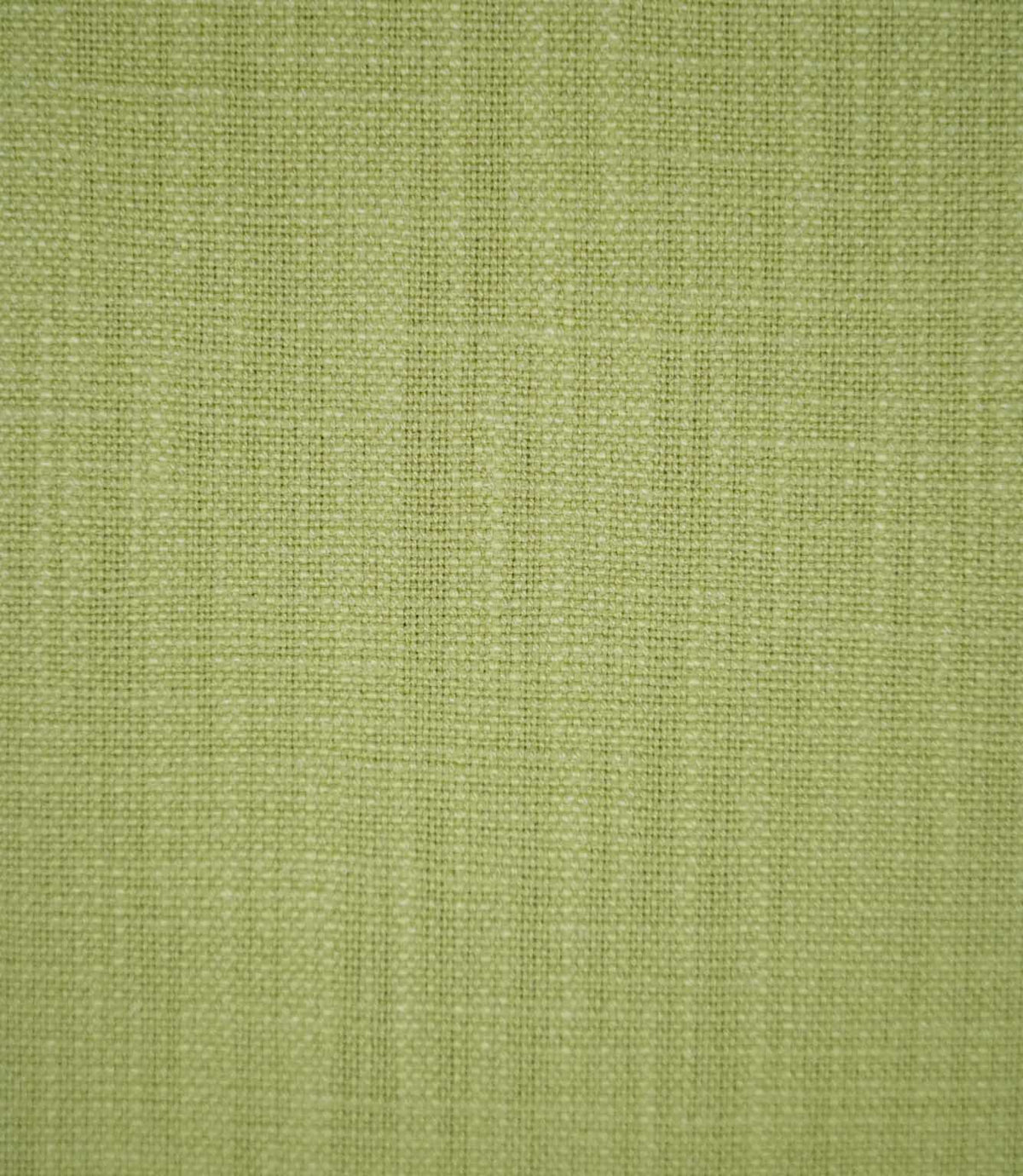 Close-up of Waverley Celery fabric in a soft green shade, showing its fine woven texture and subtle variations in the threads.