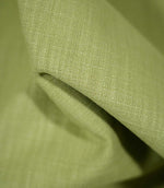 Macro photograph of Waverley Celery fabric draped into a soft fold, showing the detailed green woven threads and textured finish.