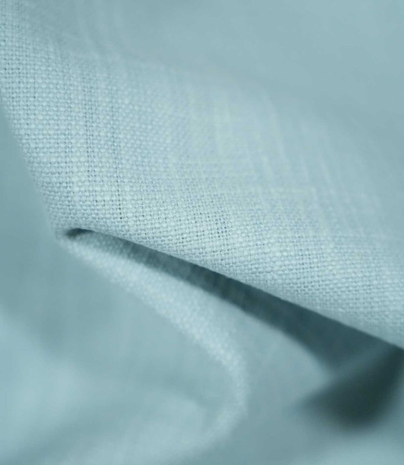Detailed close-up of Waverley Duck Egg 100% brushed cotton fabric draped into a soft fold, highlighting its textured weave and gentle pale blue-green appearance.