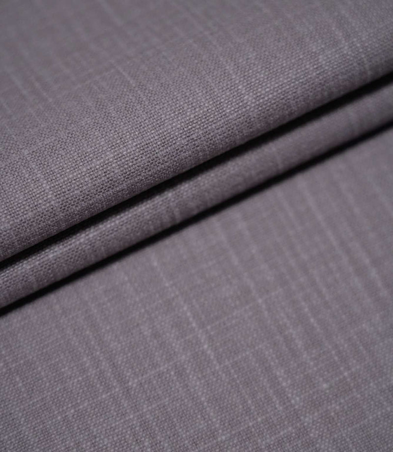 Waverley Heather plain brushed cotton fabric arranged in overlapping folds, showcasing its soft finish, subtle woven texture and dusty purple-grey colouring.