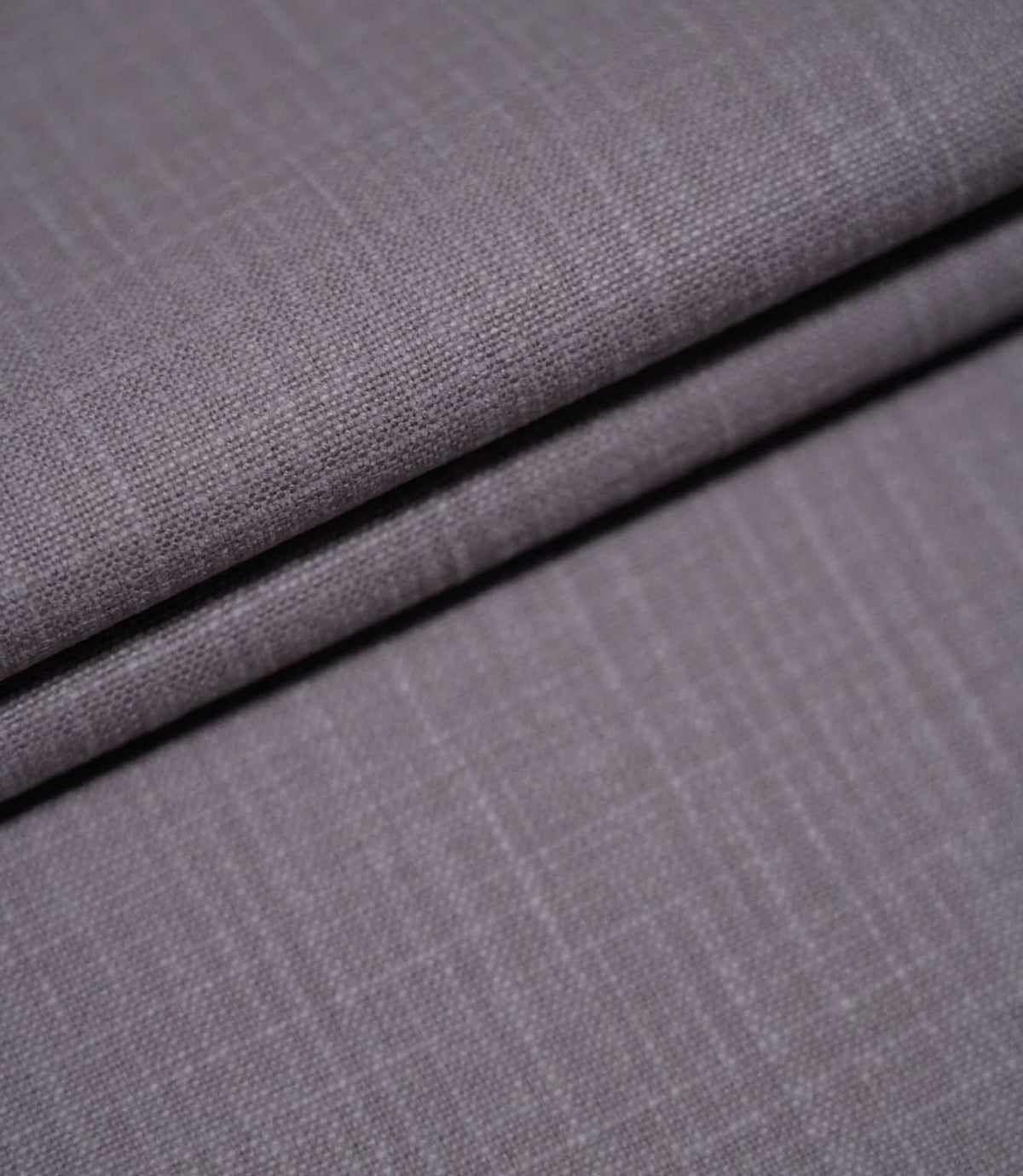 Waverley Heather plain brushed cotton fabric arranged in overlapping folds, showcasing its soft finish, subtle woven texture and dusty purple-grey colouring.