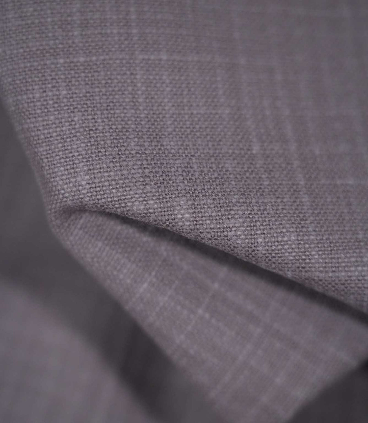 Detailed close-up of Waverley Heather brushed cotton fabric draped into a curved fold, revealing its closely woven texture and muted heather-purple appearance.