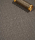 Close-up of Waverley Mink brushed cotton fabric with a coordinating taupe thread spool, highlighting the fine woven texture and warm grey-brown colouring.