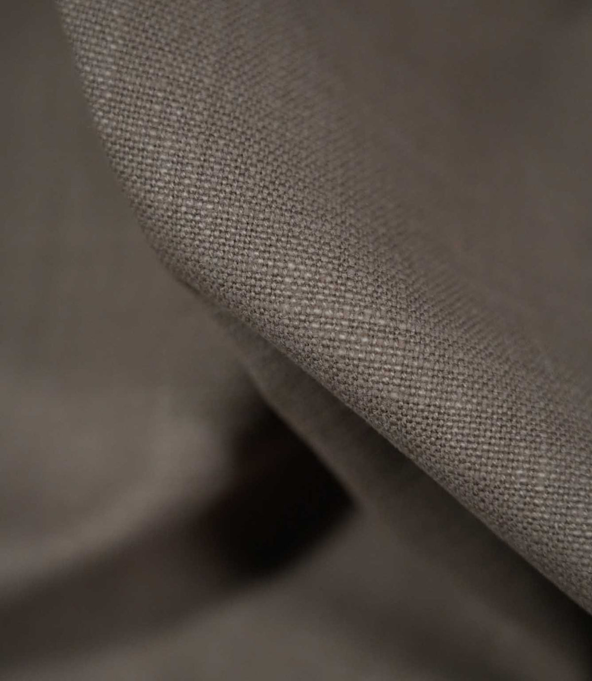 Detailed close-up of Waverley Mink 100% brushed cotton fabric draped over a curved fold, highlighting the tightly woven structure, soft brushed finish and warm taupe-grey shade.