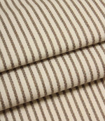 Folded Wedmore Wide ivory fabric showcasing narrow taupe stripes and a soft woven upholstery texture.
