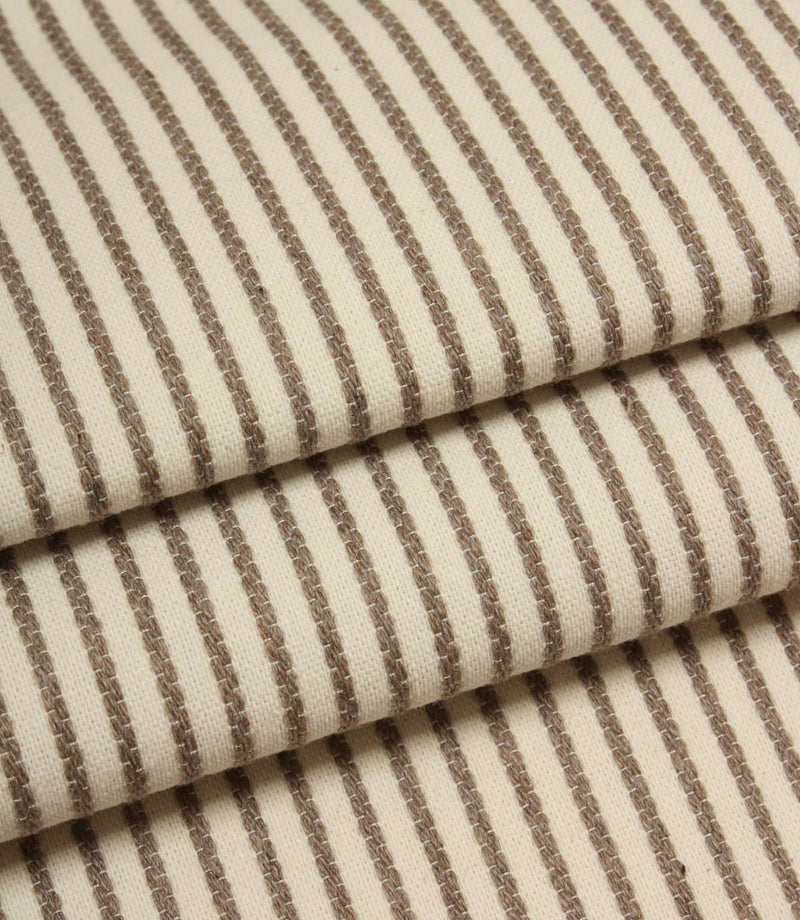 Folded Wedmore Wide ivory fabric showcasing narrow taupe stripes and a soft woven upholstery texture.