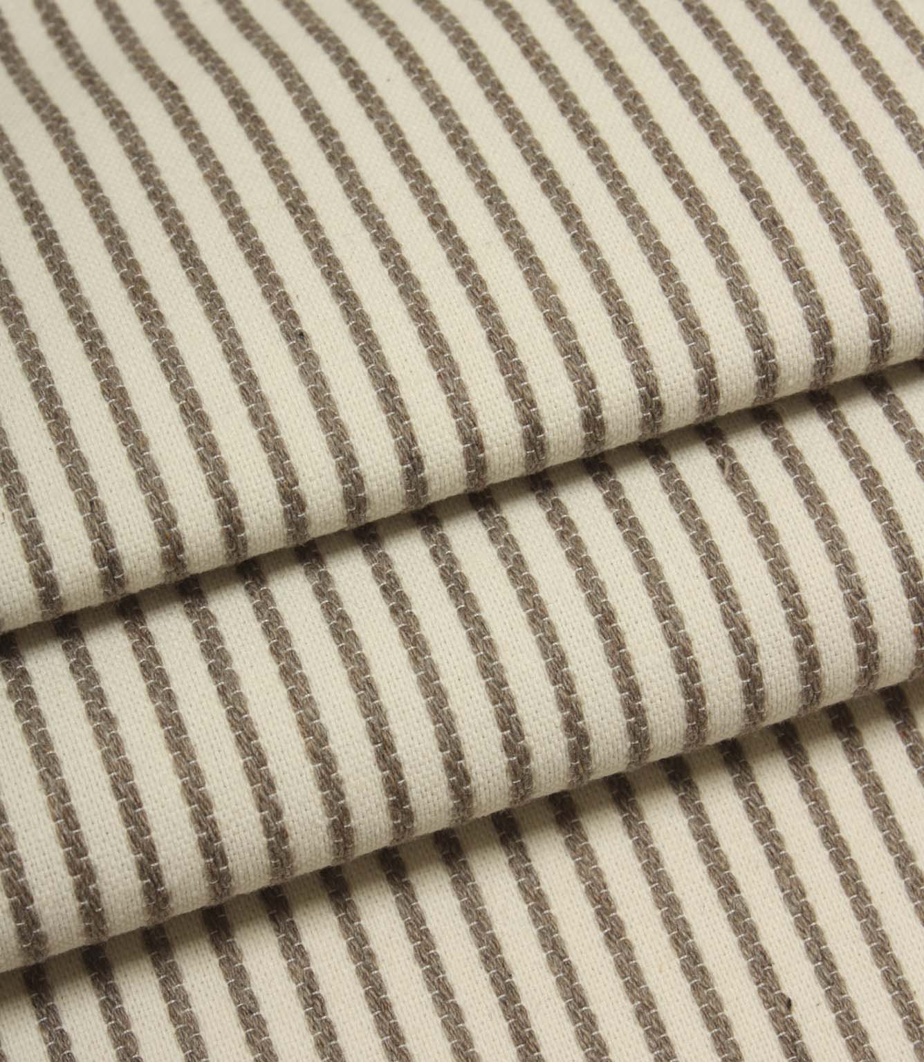 Folded Wedmore Wide ivory fabric showcasing narrow taupe stripes and a soft woven upholstery texture.