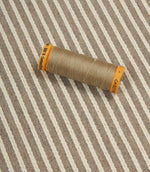 Wedmore Wide striped upholstery fabric displayed with matching thread spool to highlight texture and detailing.