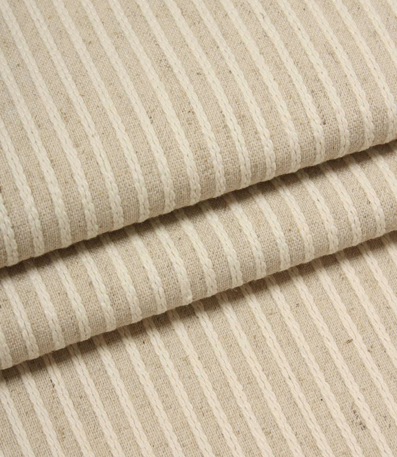Folded Wedmore Wide woven fabric showcasing fine embroidered stripe detailing and a natural upholstery finish.