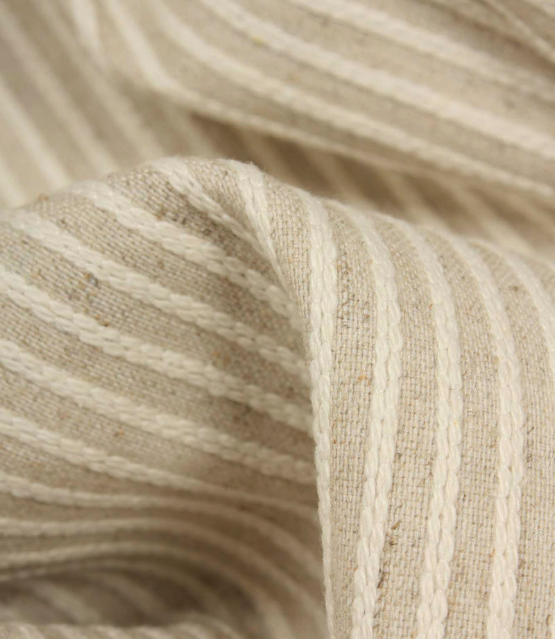 Detailed close-up of Wedmore Wide upholstery fabric featuring raised embroidered stripes on a natural woven background.