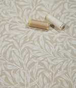 Beige and cream Willow Bough Linen Look fabric with sewing threads, showing the William Morris inspired trailing foliage design and woven texture.