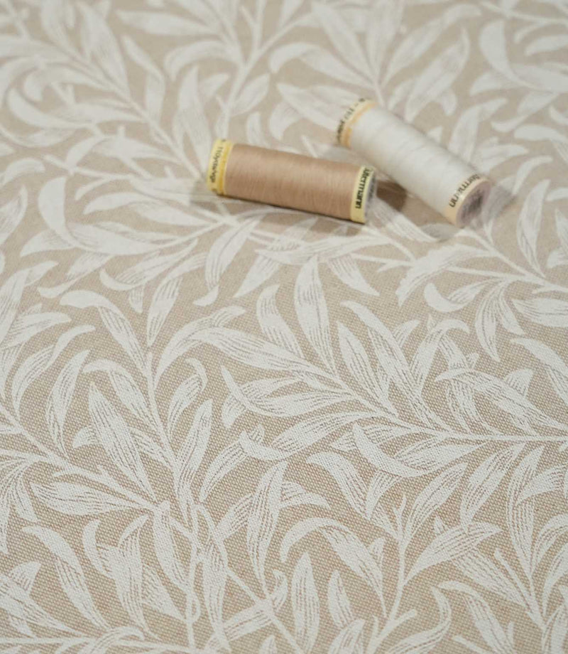 Beige and cream Willow Bough Linen Look fabric with sewing threads, showing the William Morris inspired trailing foliage design and woven texture.