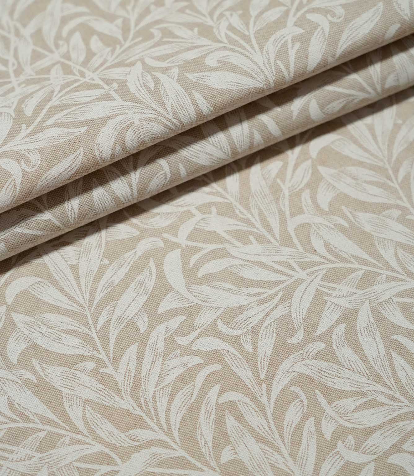Willow Bough Linen Look fabric arranged in soft folds, showing the cream foliage design against a warm beige ground and the fabric's natural drape.