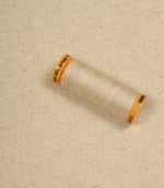 Natural plain woven fabric with spool of thread