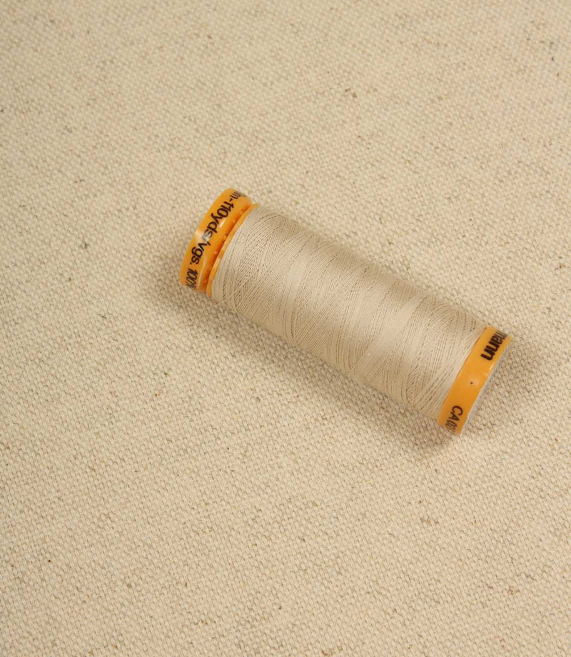 Natural plain woven fabric with spool of thread