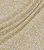 Woodcliff Oyster fabric draped in gentle, flowing folds, showcasing its small-scale oak leaf and foliage pattern in subtle oyster beige against an ivory background, with a finely woven texture and delicate branching details.
