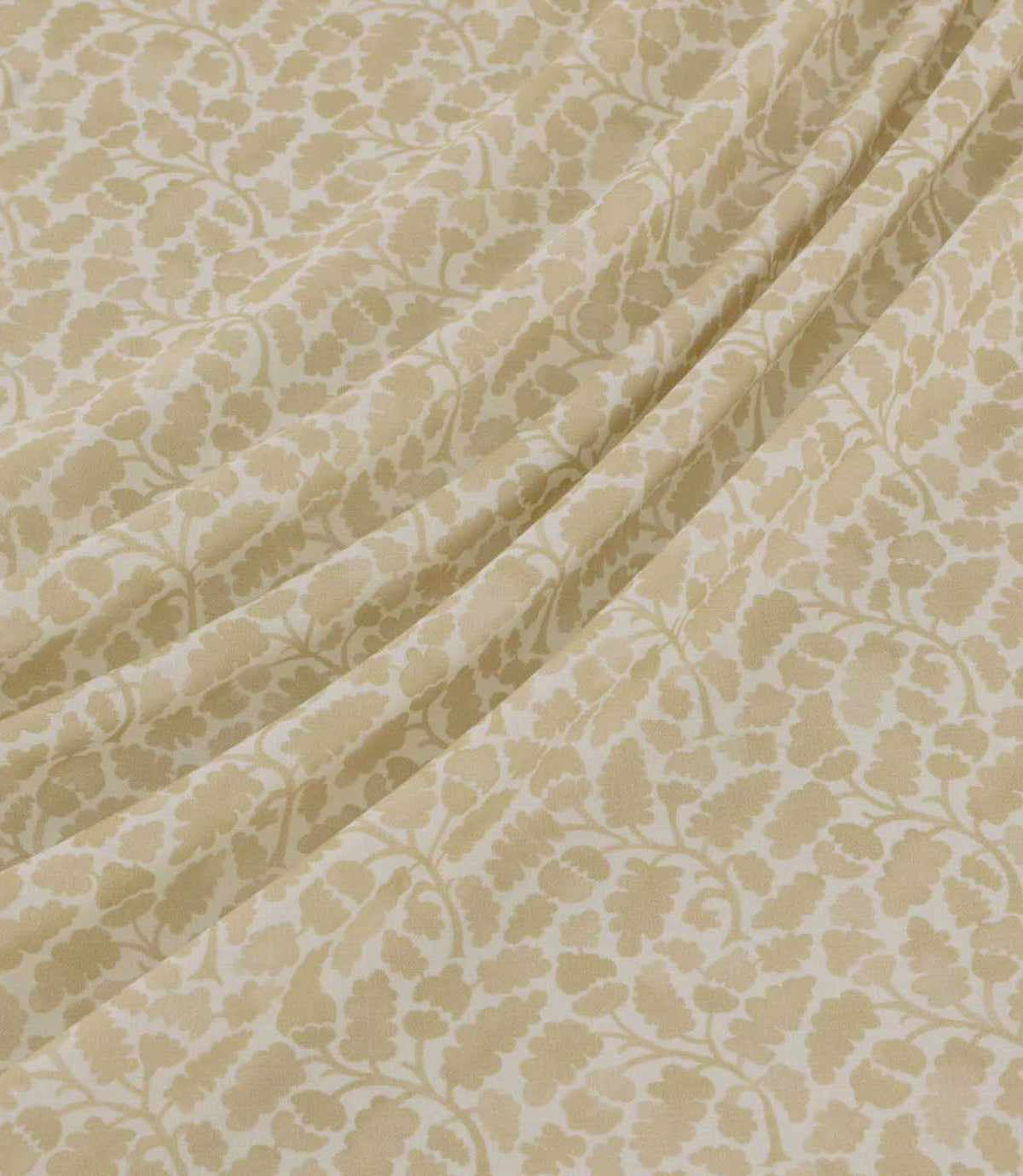 Woodcliff Oyster fabric draped in gentle, flowing folds, showcasing its small-scale oak leaf and foliage pattern in subtle oyster beige against an ivory background, with a finely woven texture and delicate branching details.