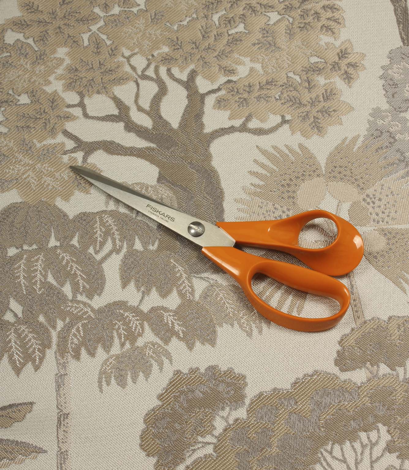 Woodlands Natural furnishing fabric with scissors for scale, showcasing the large-scale forest-inspired pattern and detailed woven construction.