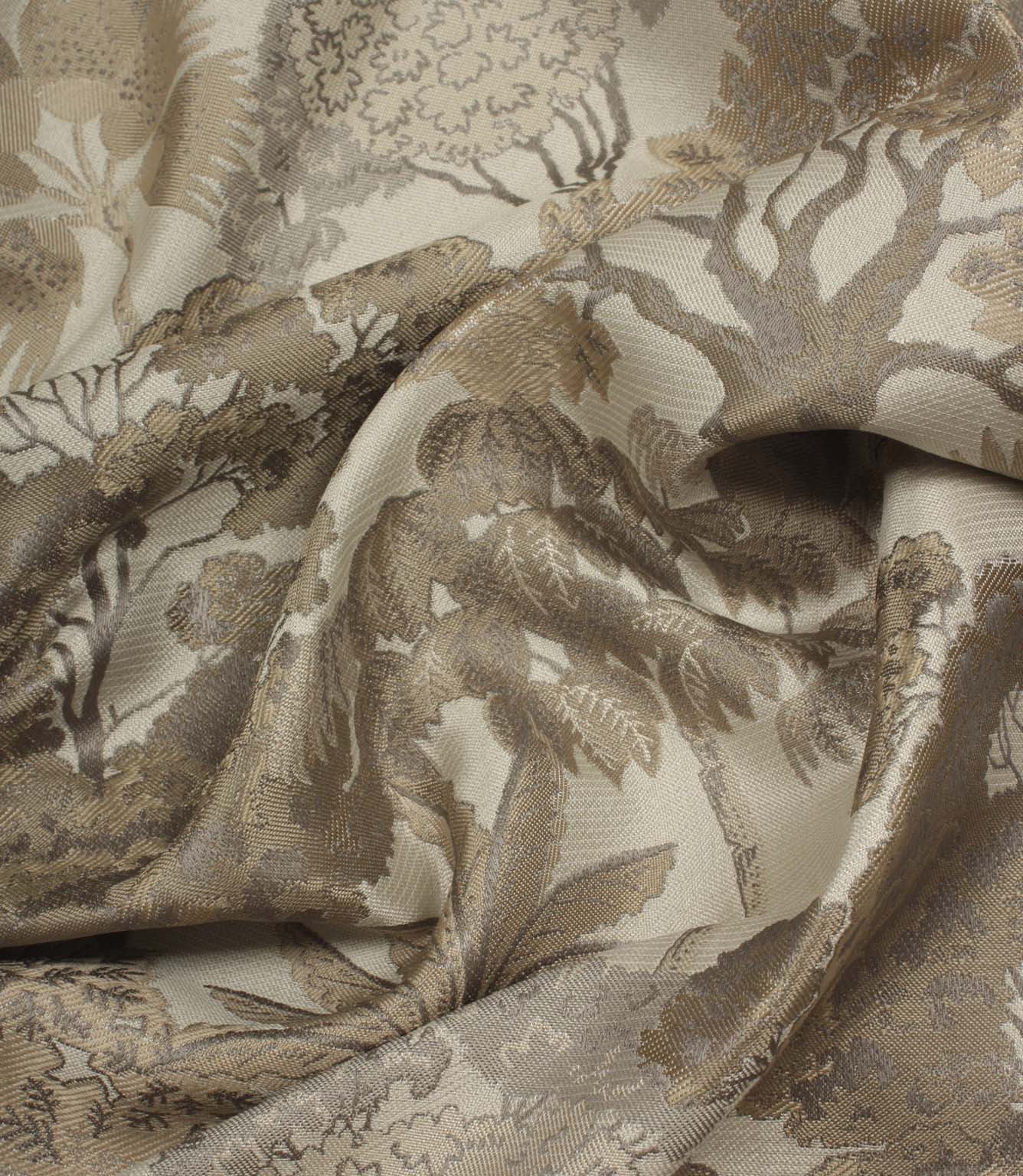 Draped Woodlands Natural fabric emphasising the luxurious handle, soft sheen and intricate woven woodland design in natural shades.