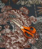 Woodlands Navy furnishing fabric with scissors for scale, showcasing the large-scale forest pattern and woven texture.