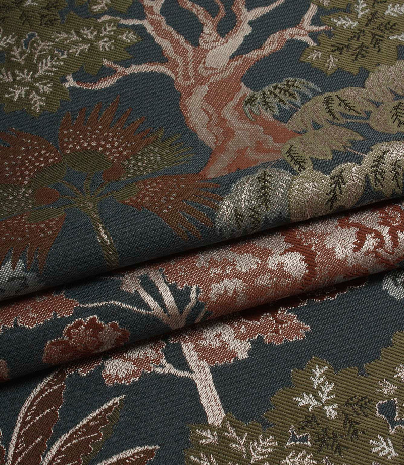 Folded Woodlands Navy fabric displaying the decorative woodland motif, including trees, foliage and layered colour detail.
