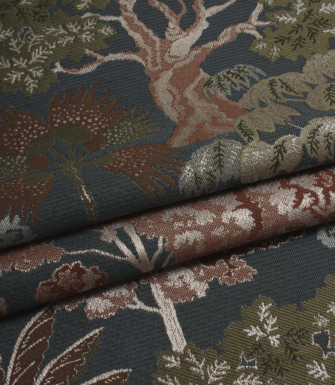 Folded Woodlands Navy fabric displaying the decorative woodland motif, including trees, foliage and layered colour detail.