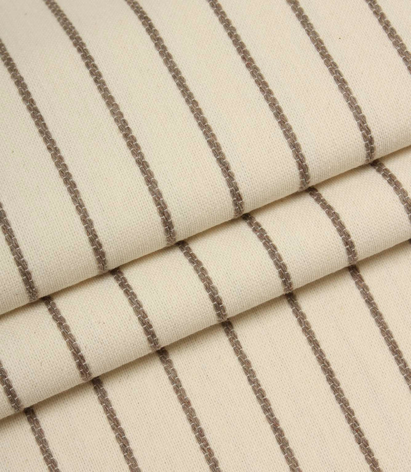 Folded Wooton Wide woven fabric showcasing embroidered stripe detailing and a soft upholstery finish.