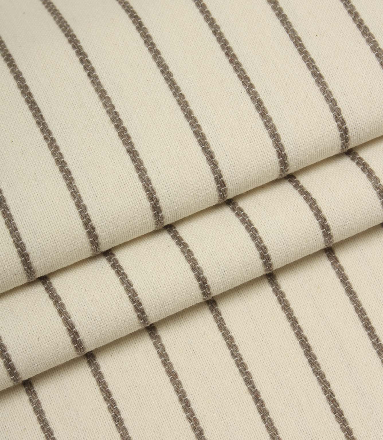 Folded Wooton Wide woven fabric showcasing embroidered stripe detailing and a soft upholstery finish.