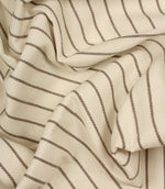 Draped Wooton Wide striped fabric with flowing folds, showing its relaxed woven texture and embroidered stripe pattern.