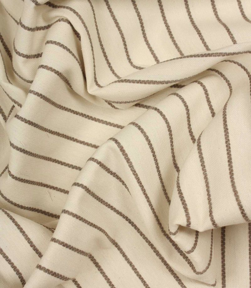 Draped Wooton Wide striped fabric with flowing folds, showing its relaxed woven texture and embroidered stripe pattern.
