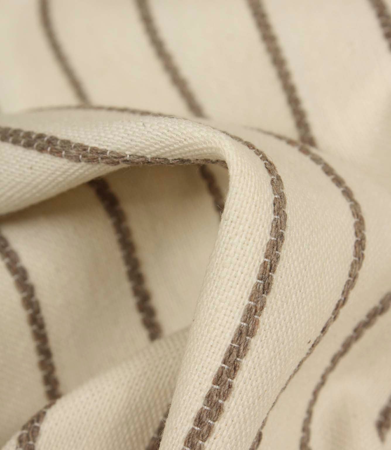 Detailed close-up of Wooton Wide upholstery fabric featuring raised embroidered stripes on a soft woven surface.