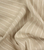 Draped Wooton Wide striped fabric showcasing its soft handle and natural woven texture for curtains and cushions.