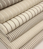 Coordinating striped upholstery fabrics from the Wedmore collection displayed folded together in complementary woven designs.