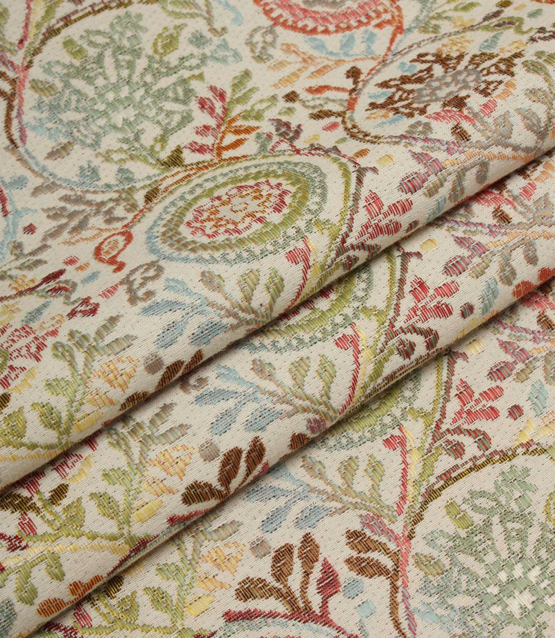 Folded Wychwood Jasmine woven fabric showcasing the detailed floral and foliage pattern in soft blue, green, coral and neutral tones.